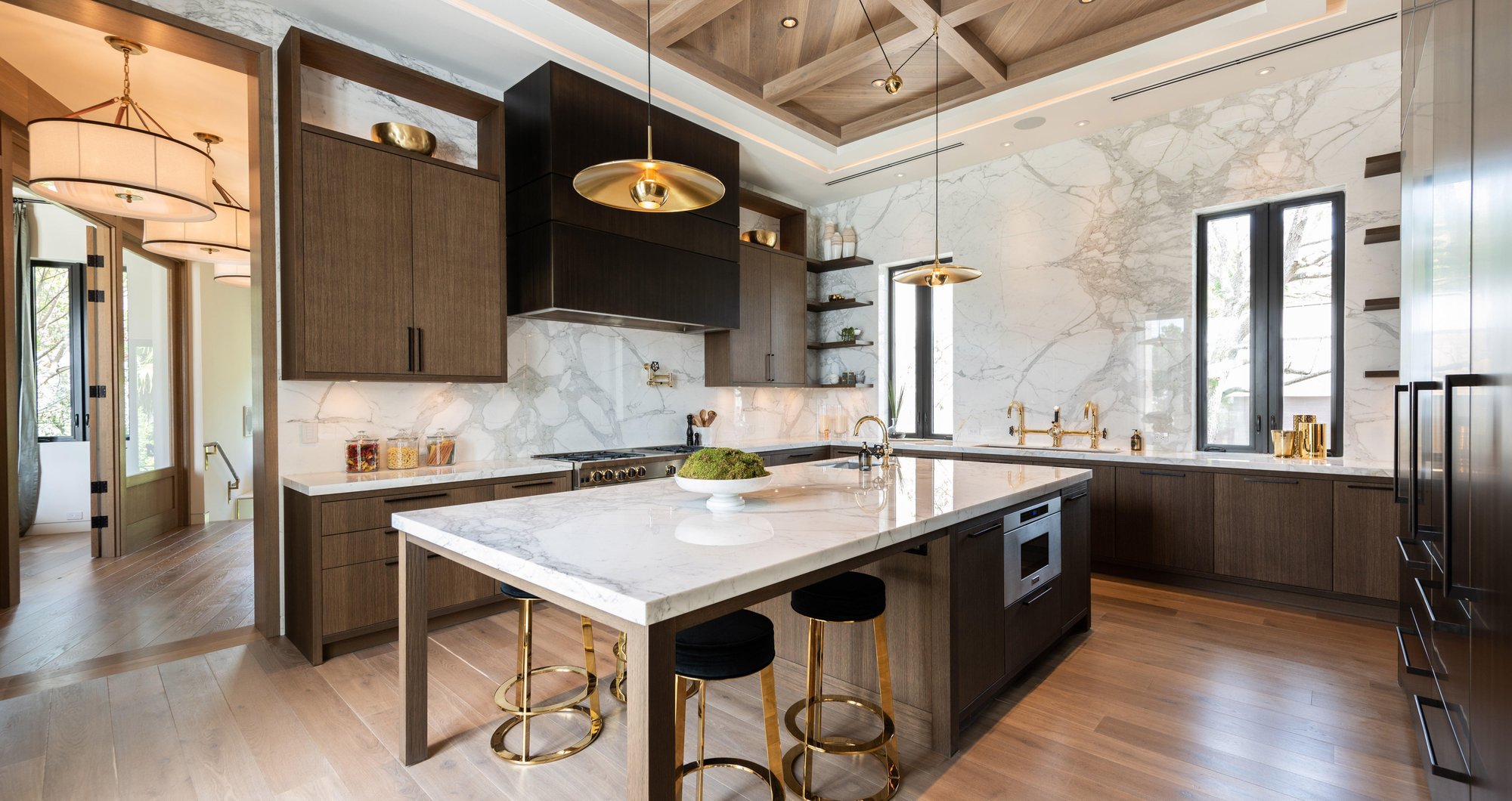 Modern Italian kitchen and living space with white marble island and custom cabinetry. Modern Italian kitchen and living space with white marble island and custom cabinetry.